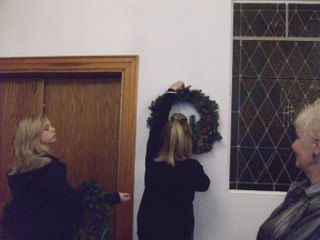 Jacyee holds wreaths as Jennifer places them